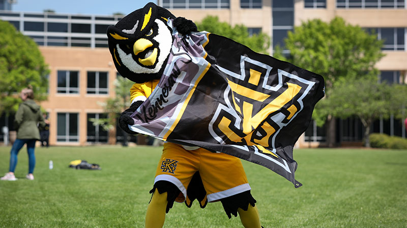 Kennesaw State University's mascot holding the university flag